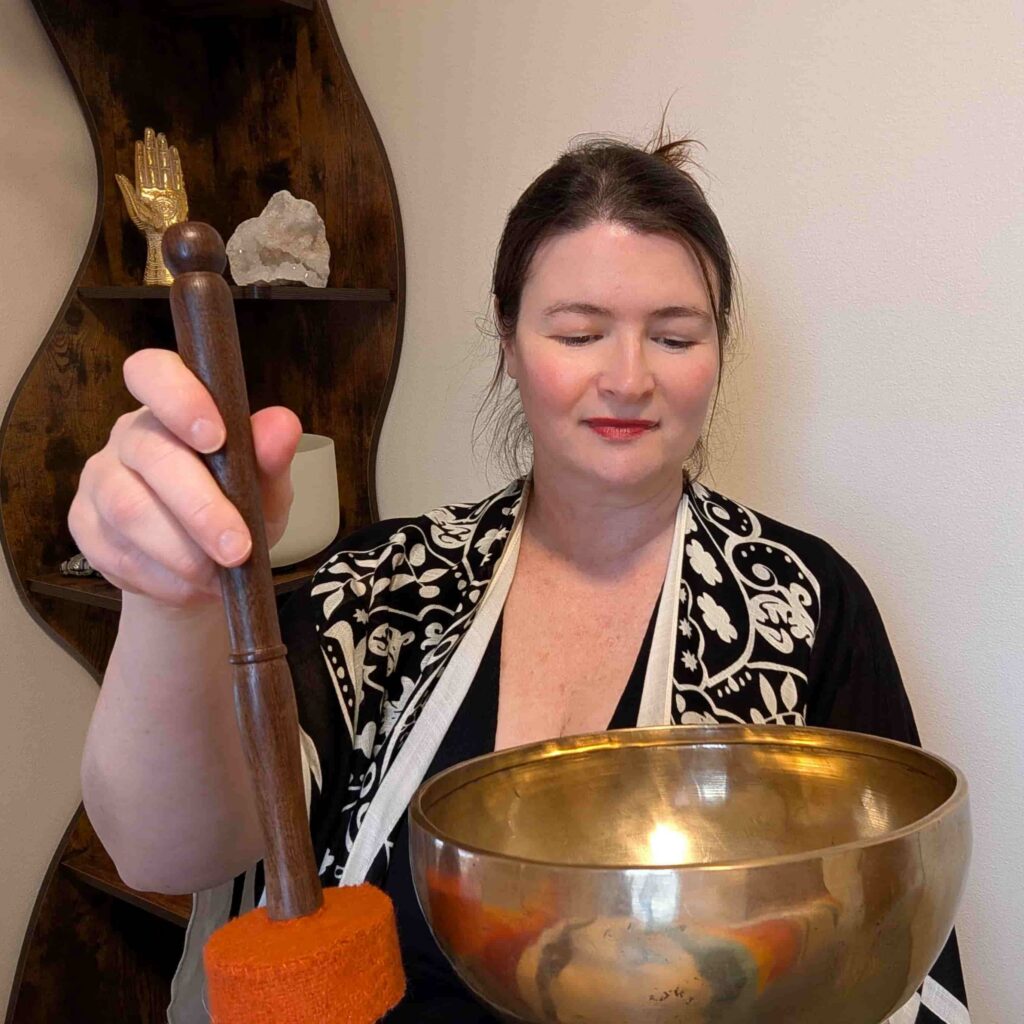 Lara Dunning strikes a Tibetan healing singing bowl.