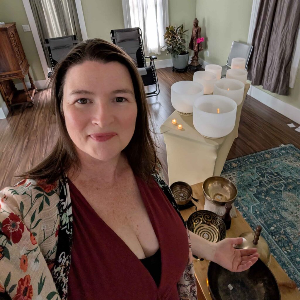 Sound healing practitioner Lara Dunning with crystal singing bowls and Tibetan bowls set up for a community sound bath