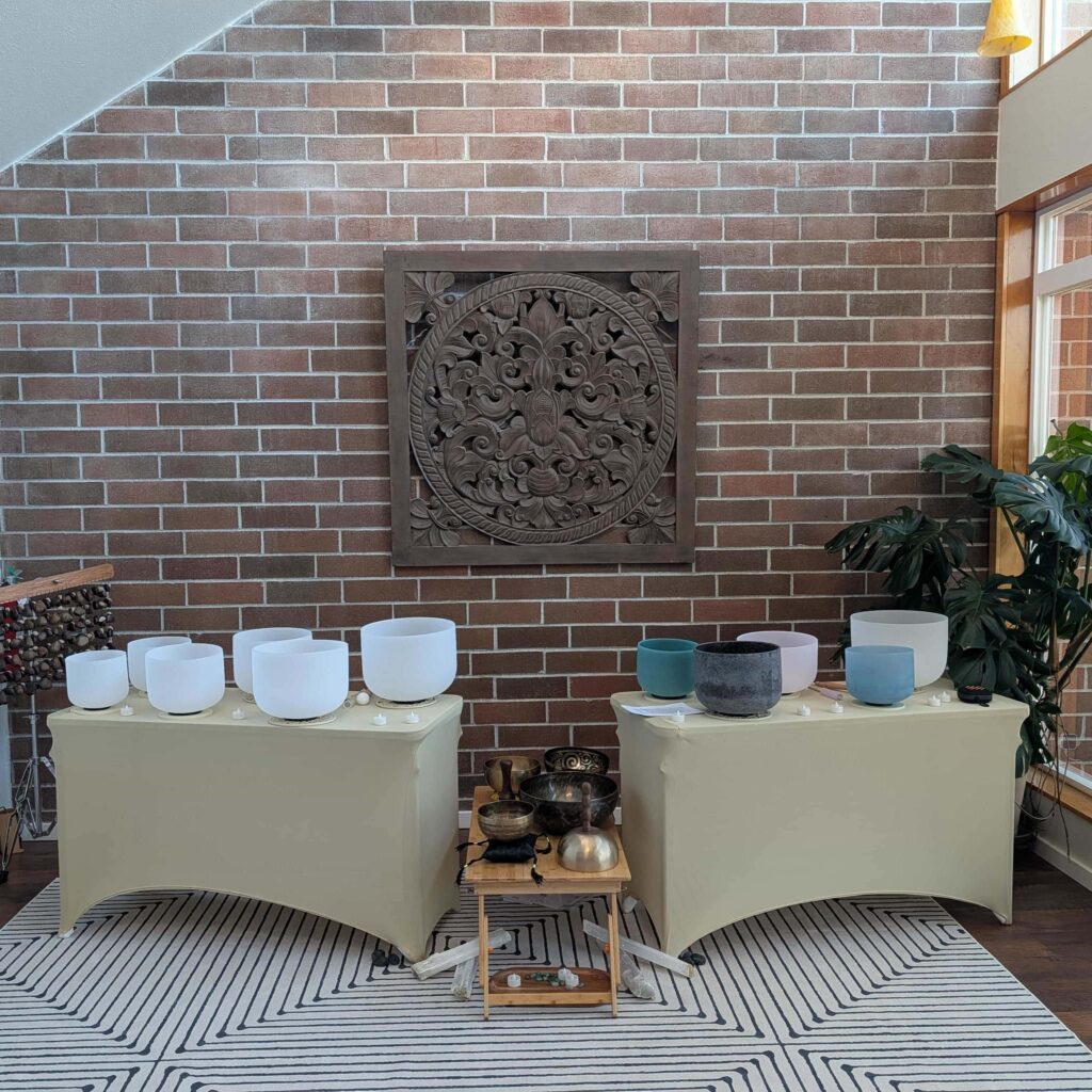 Sound bath set up with crystal singing bowls, solfeggio singing bowls, tibetan bowls, chimes, and crystals. 